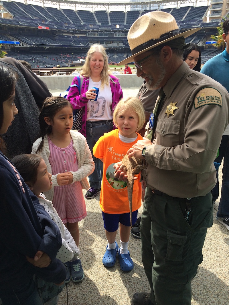 Ranger Kyle from County Parks and Recreation shares a bearded dragon with young and the young at heart at a previous STEM Festival event.