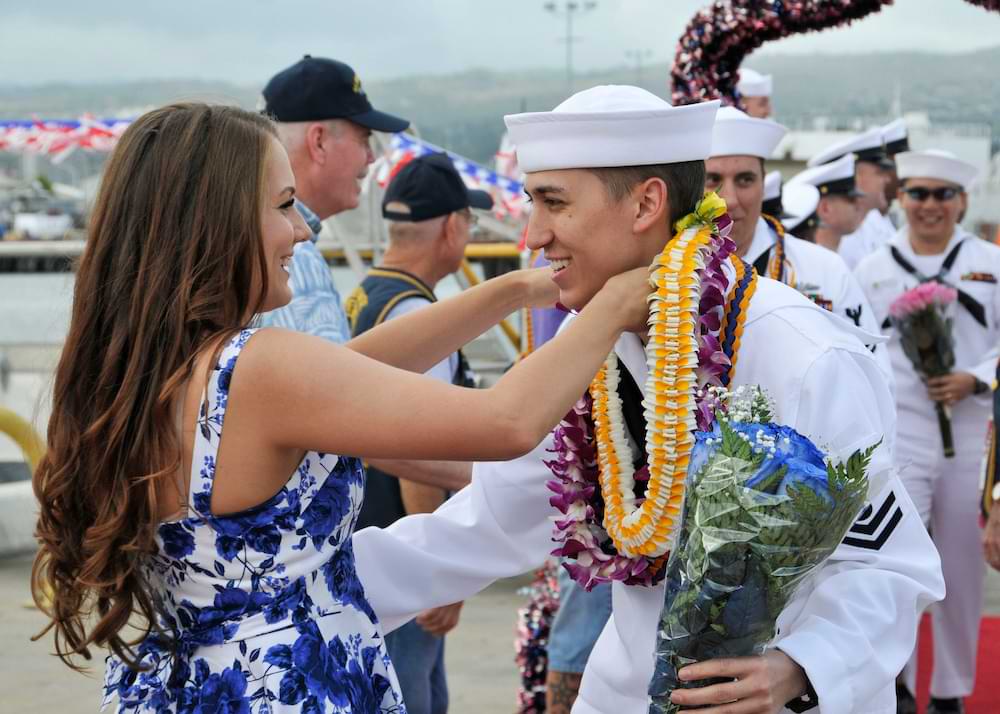 Electrician's Mate 2nd Class Joshua Nimis from the Los Angeles-class fast attack submarine USS Columbus (SSN 762) hugs his girlfriend at the submarine piers on Joint Base Pearl Harbor-Hickam following the return of the submarine from a six-month deployment to the western Pacific region. (U.S. Navy photo by Mass Communication Specialist 1st Class Steven Khor/Released)