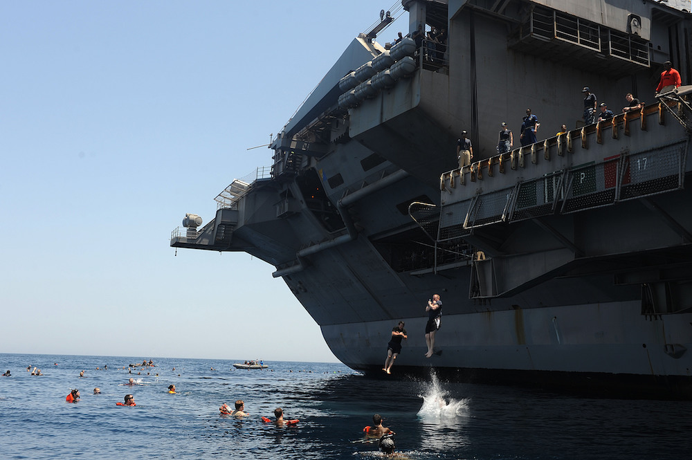 NORTH ARABIAN SEA (May 12, 2013) Sailors jump from an aircraft elevator during a swim call aboard the aircraft carrier USS Dwight D. Eisenhower (CVN 69). Dwight D. Eisenhower is deployed to the U.S. 5th Fleet area of responsibility promoting maritime security operations, theater security cooperation efforts and support missions as part of Operation Enduring Freedom. U.S. Navy photo by Mass Communication Specialist 2nd Class Ryan D. 